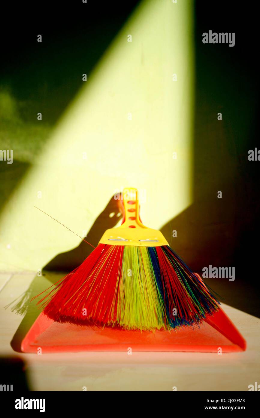 Dirty dustpan and colourful brush Stock Photo