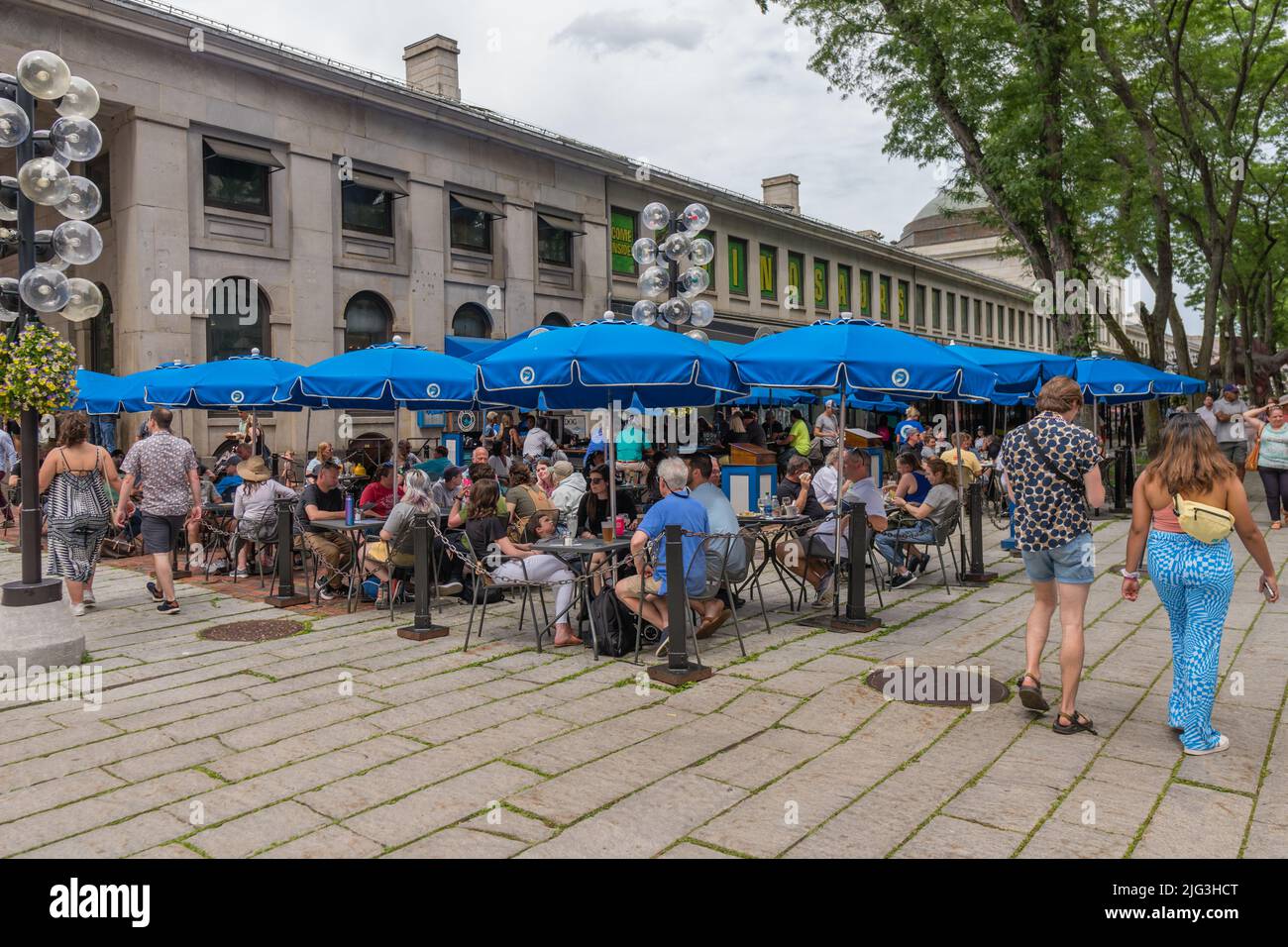 Boston, MA, US-June 11, 2022: People eating at outdoor restaurant in summer at busy tourist destination. Stock Photo