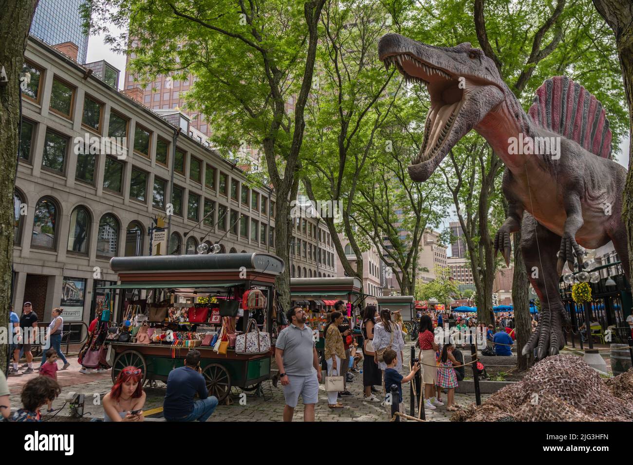 Boston, MA, US-June 11, 2022: People at busy downtown food market and tourist destination with large dinosaur statue in background. Stock Photo
