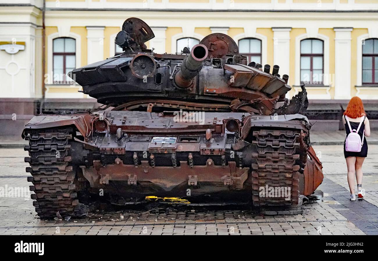 A woman walks past a destroyed Russian tank displayed St Michael's Square, Kyiv Ukriaine. Picture date: Thursday July 7, 2022. Stock Photo
