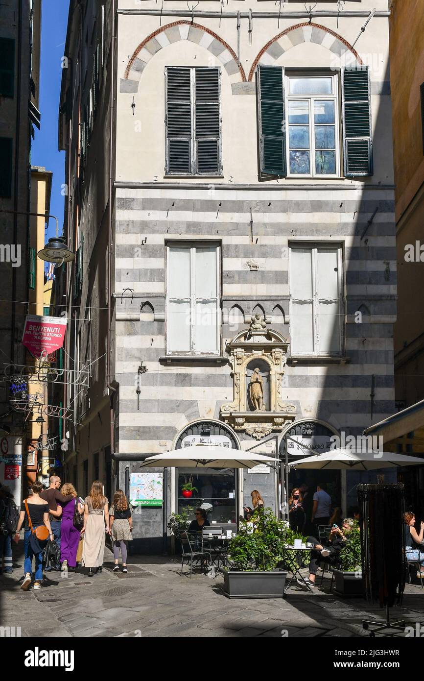 Piazza di Soziglia with the votive shrine of St John the Baptist on the façade of the Palazzo della Dogana (Customs House) and tourists, Genoa, Italy Stock Photo