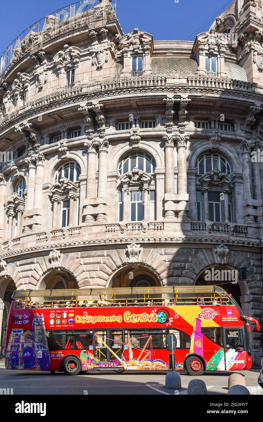 A sightseeing bus passing in front of the Palazzo della Borsa (Stock Exchange Palace) in Piazza De Ferrari, city centre of Genoa, Liguria, Italy Stock Photo
