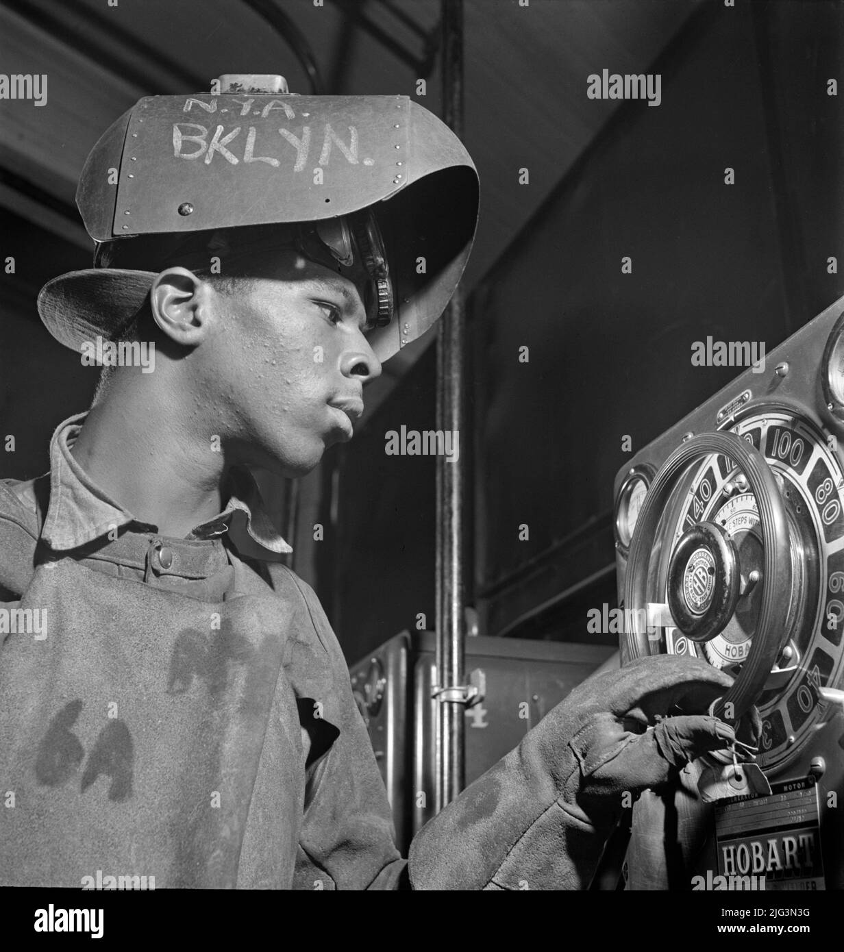 Young Adult Man receiving training in arc welding, National Youth Administration (NYA) Work Center, Brooklyn, New York, USA, Fritz Henle, U.S. Office of War Information/U.S. Farm Security Administration, August 1942 Stock Photo