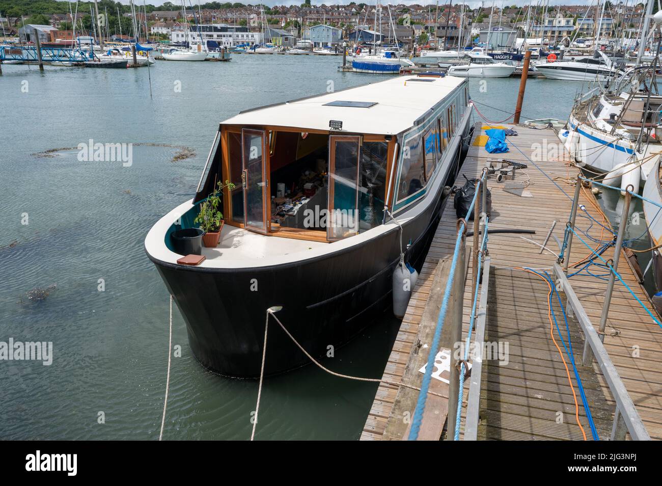 Probably the first wide beam boat build on the Isle of Wight moored in the harbour while being completed by the builders Floating Ohm. Stock Photo