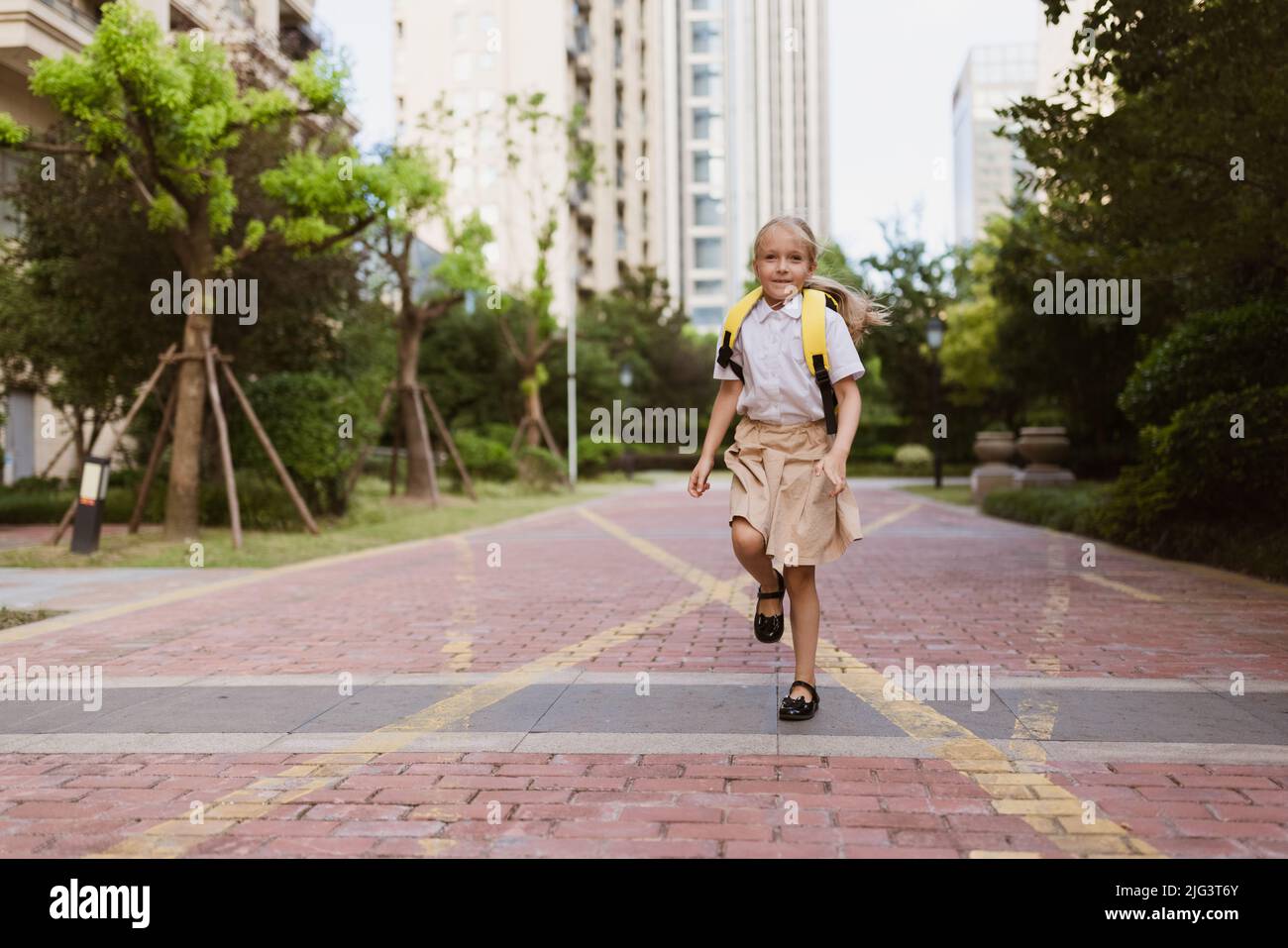 Schoolgirl back to school after summer vacations. Child in uniform ...