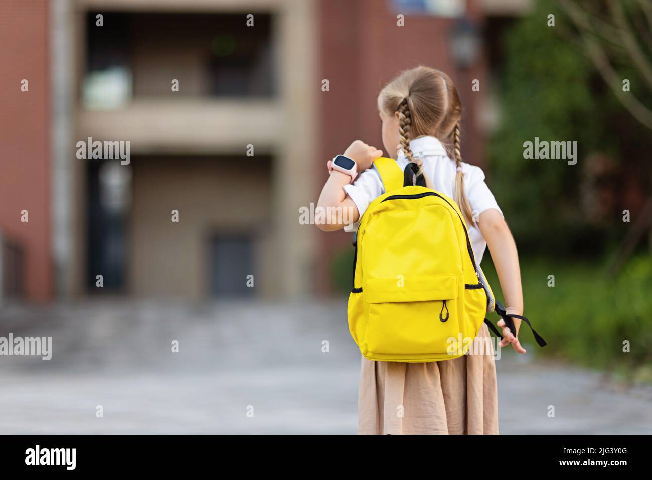 Schoolgirl back to school after summer vacations. Child in uniform ...