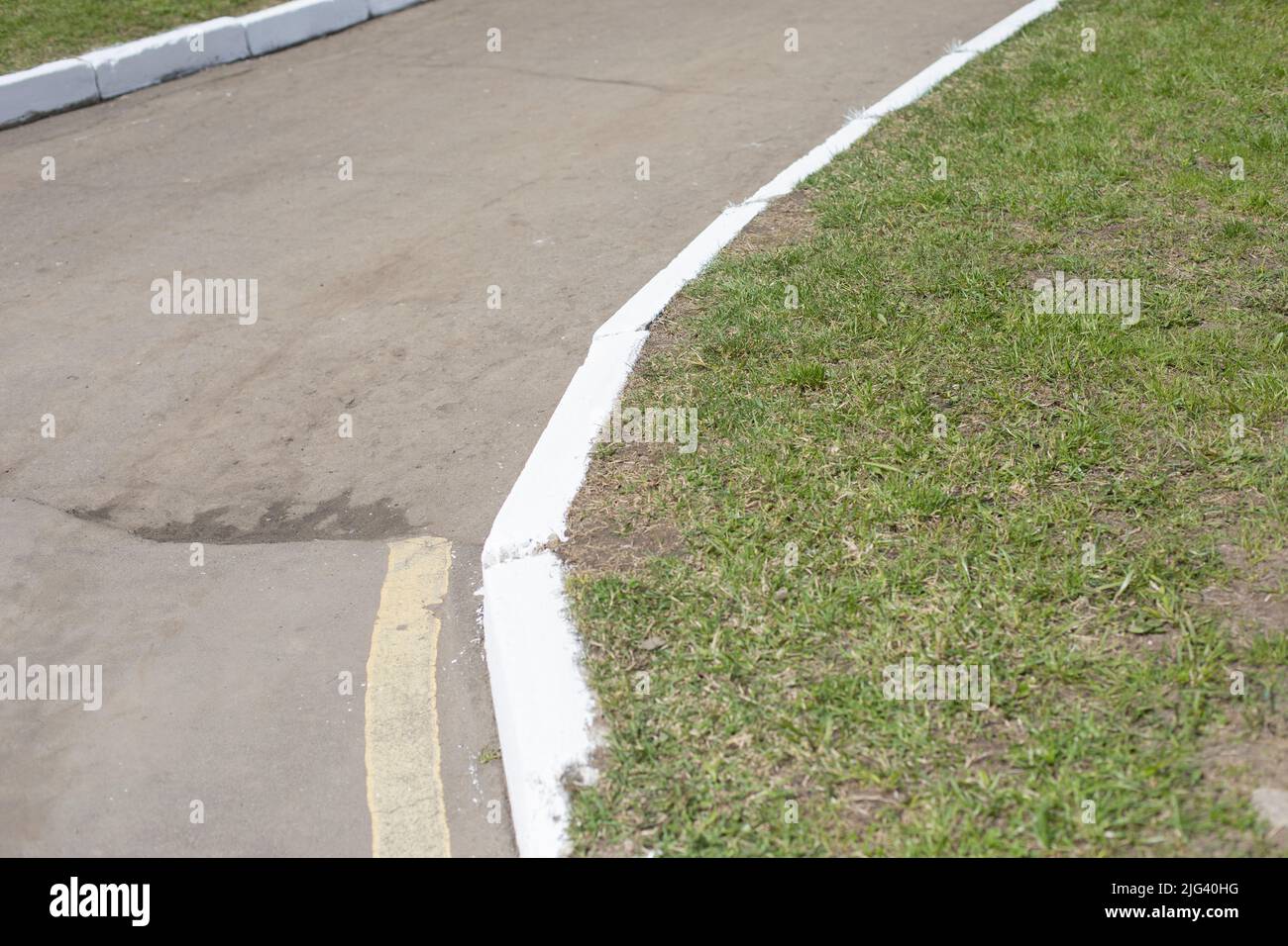 White curb on road. Landscaping in park. Painted curb Stock Photo Alamy
