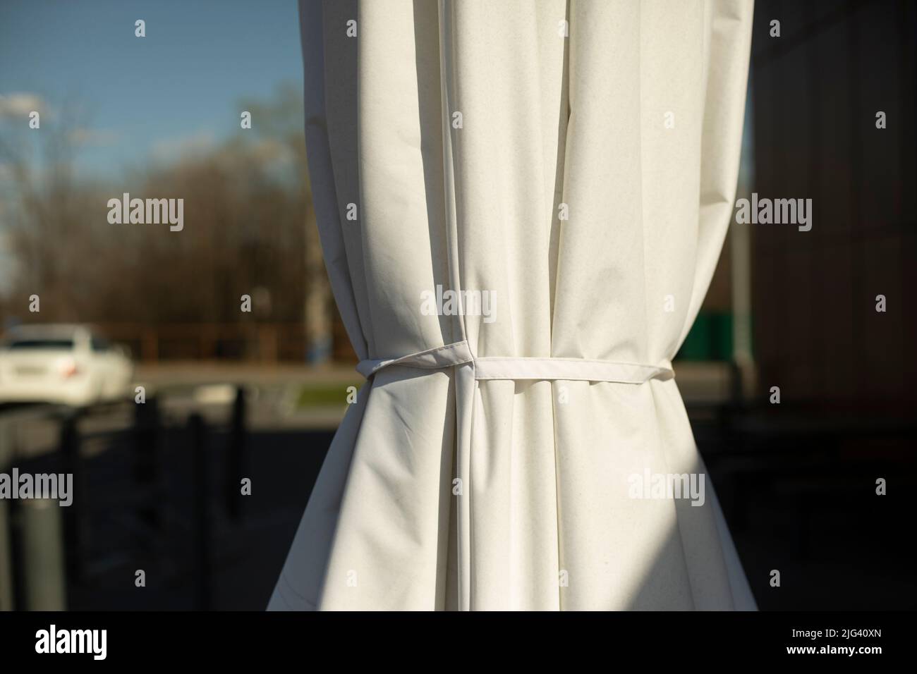 White umbrella on veranda. Sun protection. Stock Photo