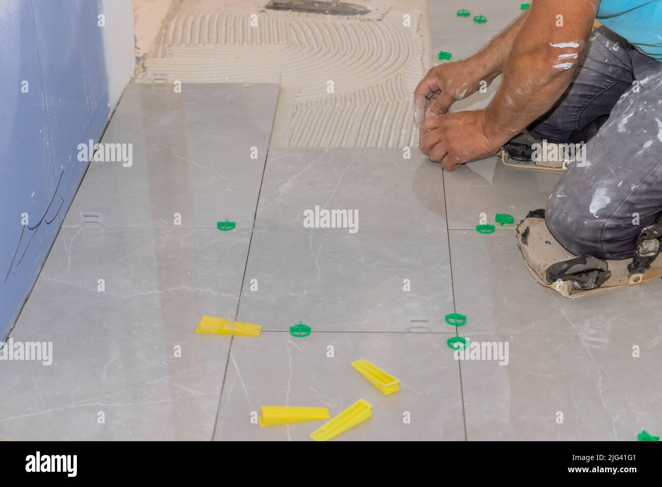 Working on the tile leveling system in the bathroom with plastic clips