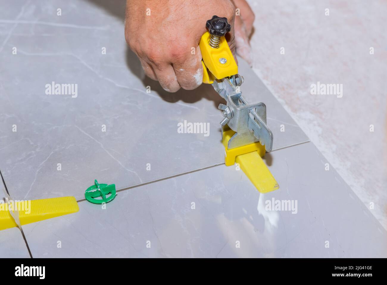 Work in a bathroom with a tile leveling system made up of plastic clips