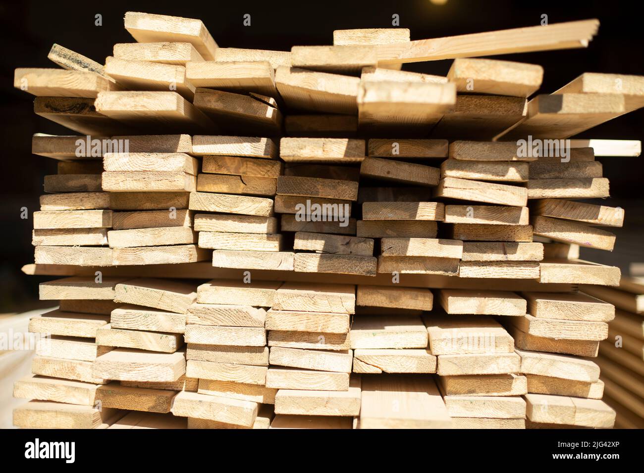 Boards in stock. Boards in sunlight. Lot of blanks made of wood. Stock Photo