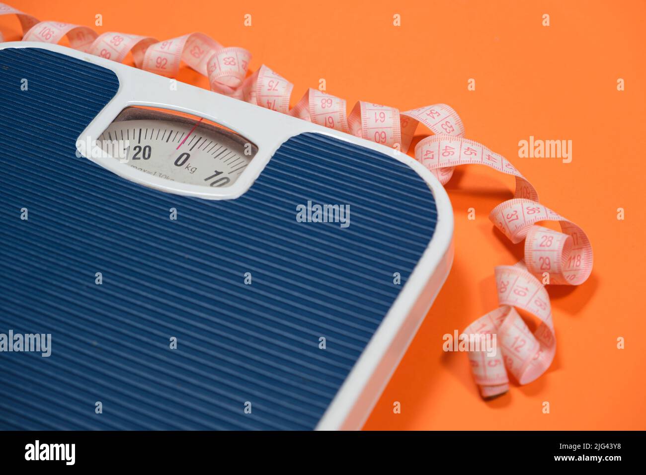 https://c8.alamy.com/comp/2JG43Y8/floor-blue-scales-and-centimeter-measuring-tape-on-an-orange-background-top-view-the-concept-of-weight-loss-and-weight-control-2JG43Y8.jpg