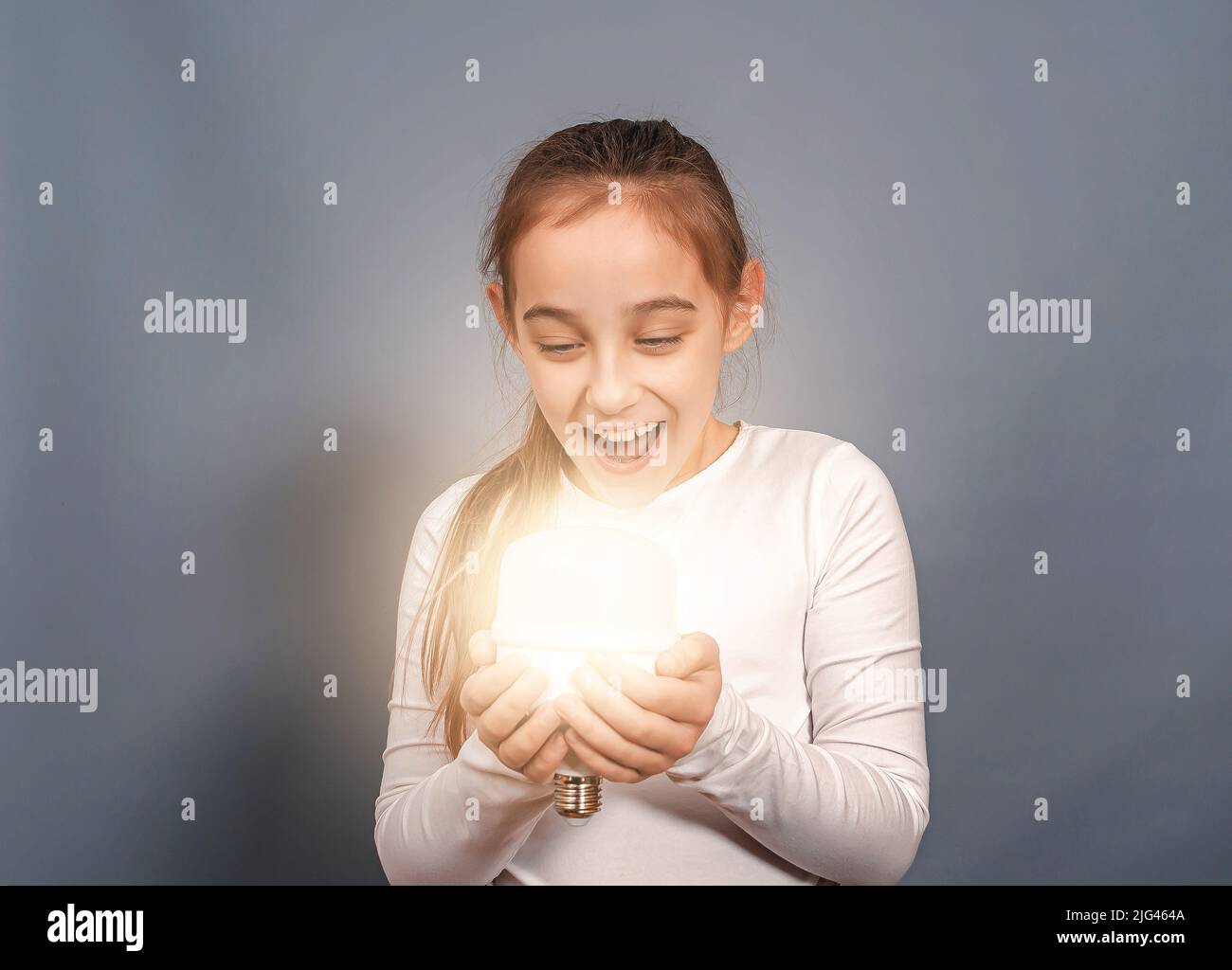 Portrait of happy joyful child with light bulb. Emotion of surprise. Stock Photo