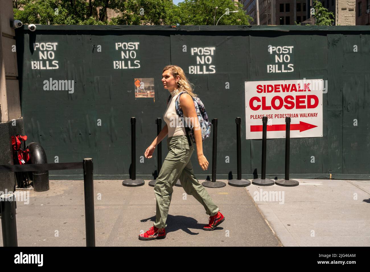 Woman passes a sidewalk shed at a construction site in New York on Friday, June 24, 2022.  (© Richard B. Levine) Stock Photo