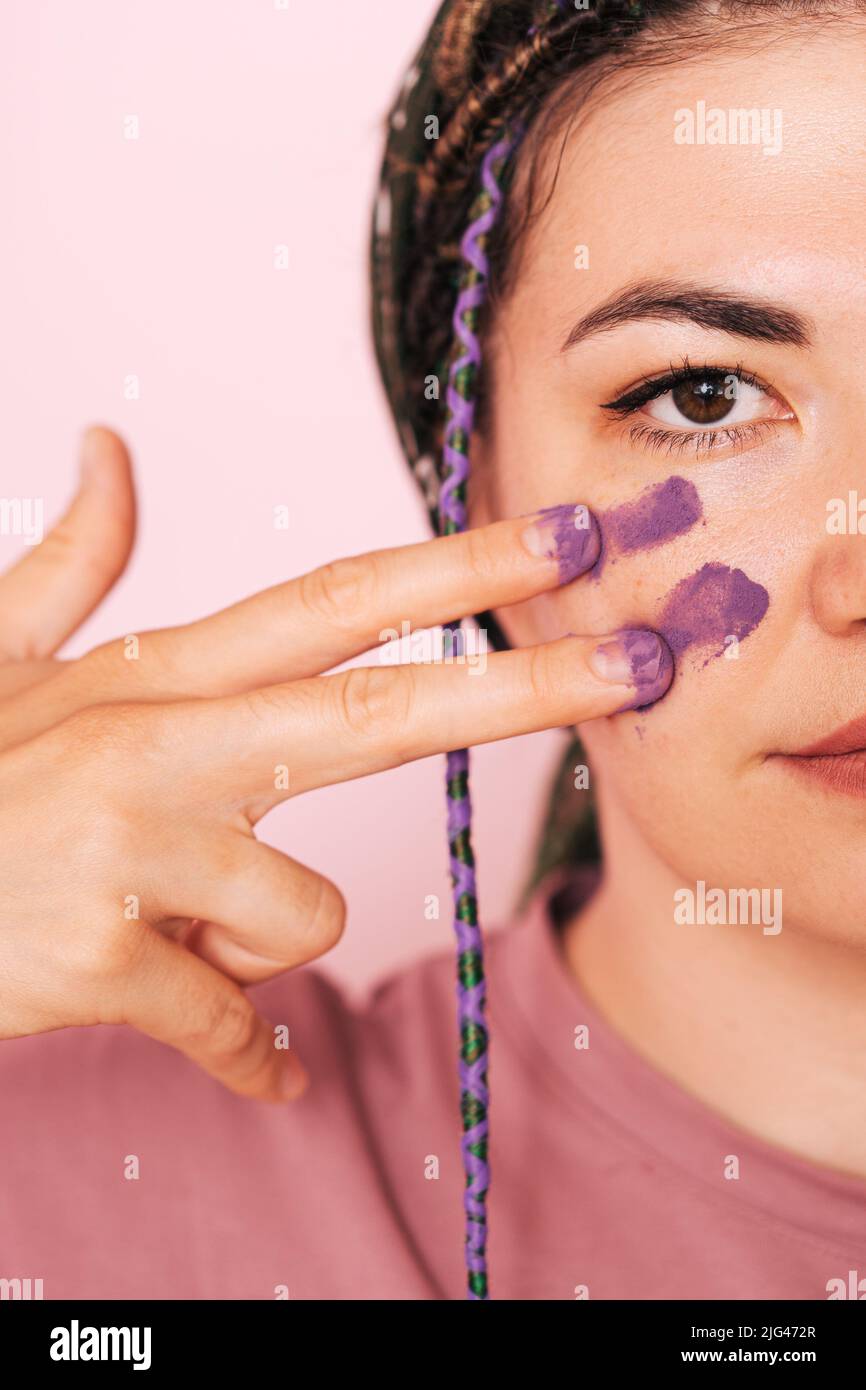 Girl paints half of her face with purple paint Stock Photo Alamy
