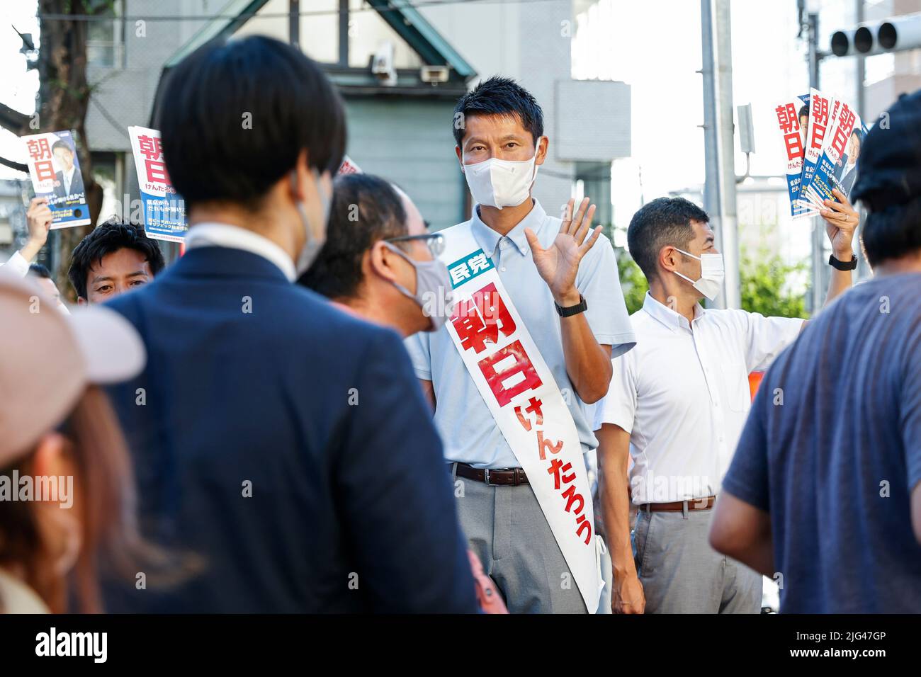 Kentaro Asahi greets pedestrians outside Tokyo Dome on July 7, 2022, in