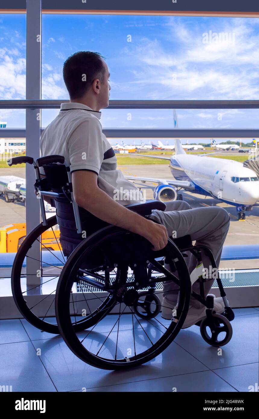 Young man in a wheelchair at the airport closeup Stock Photo