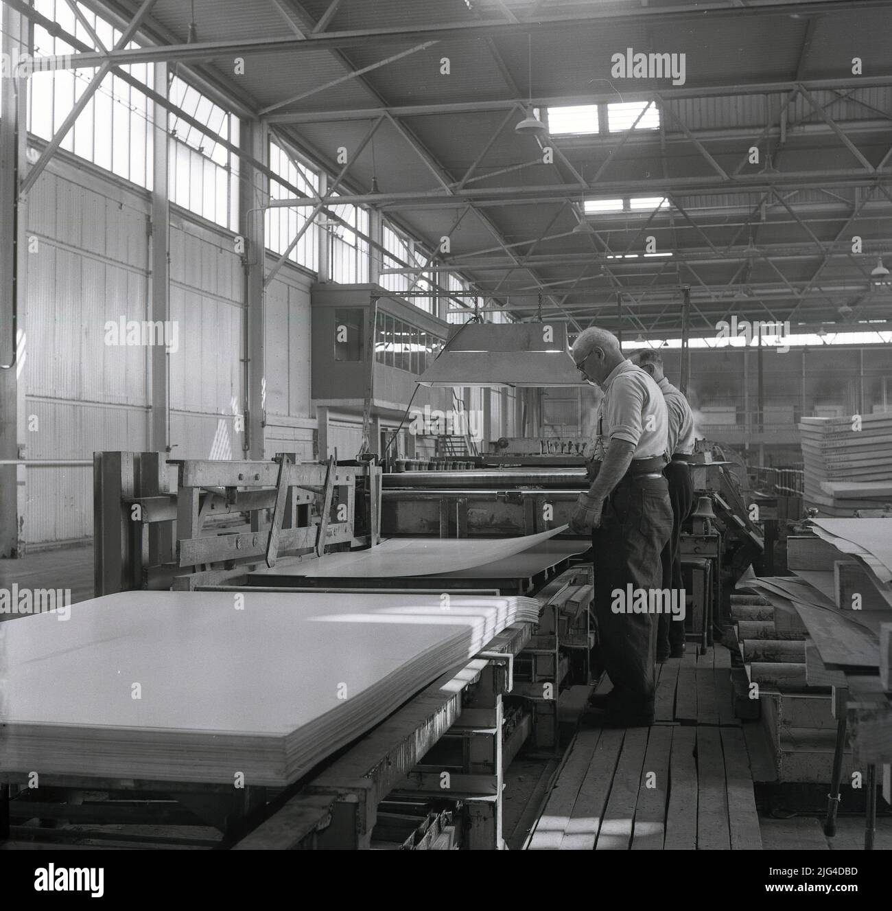 1950s, historical, two steelworkers processing finished sheets of pressed steel, Abbey steelworks, Port Talbot, Wales. UK Stock Photo