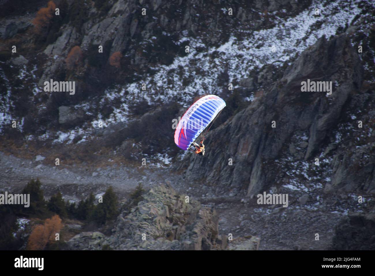Paragliding flies through the air from Le Brévent to Chamonix in autumn Stock Photo