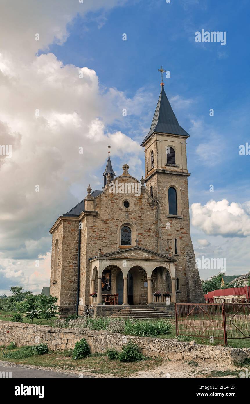 Cloudy landscape with stone church. Catholic church on background of ...