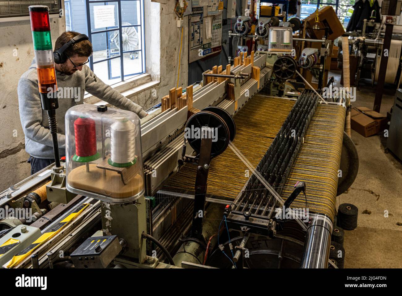 Loom operator. Weaving machine, looms and weaver, Melin Tregwynt, a 200-year-old wool Miil, Tregwynt Mill, Pembrokeshire, Wales, UK Stock Photo