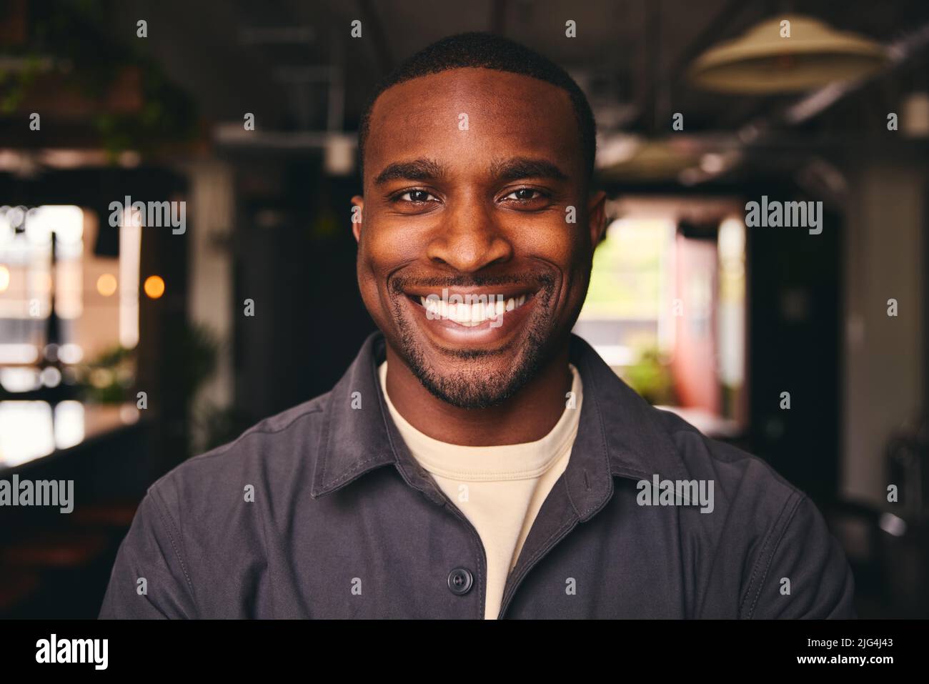 Smiling Young Black Male Standing In Office Looking At Camera Stock Photo