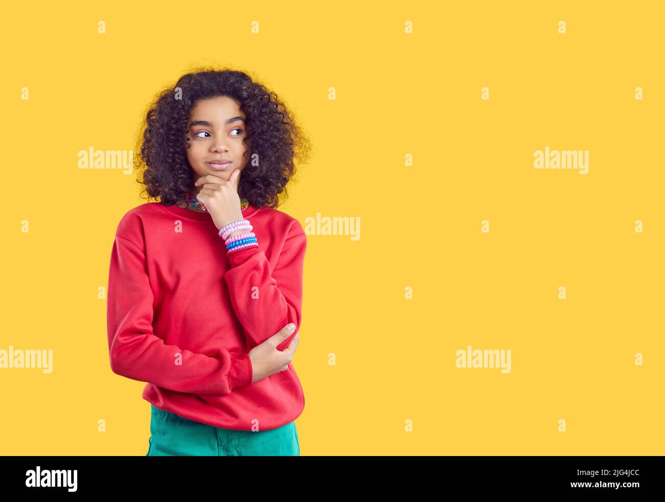 Cute smiling teen girl dreams, thinks, makes decisions or comes up with cunning plan. Stock Photo