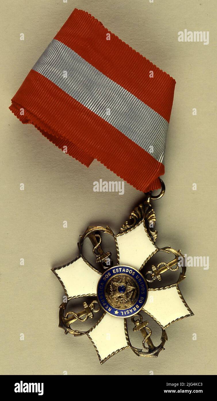 Encomienda of the Order of Military Merit, Brazil. Encomienda. Order of Military-Brazil. Encomienda. Award on cross cross that is carried on plate, pending neck or chest, according to categories. It hangs from a Vermelhá (red) colored silk moaré tape, with a blue-clarh central list, equivalent to the third part of its total width. Annverse: Golden Cross, with four equal arms, curvilinear edges that widen towards their ends ending at acute, smooth, plans and white enameled angle. Interpolated between the arms of the cross, paths of gold with stock, argon and zucchini. On the point of union of t Stock Photo