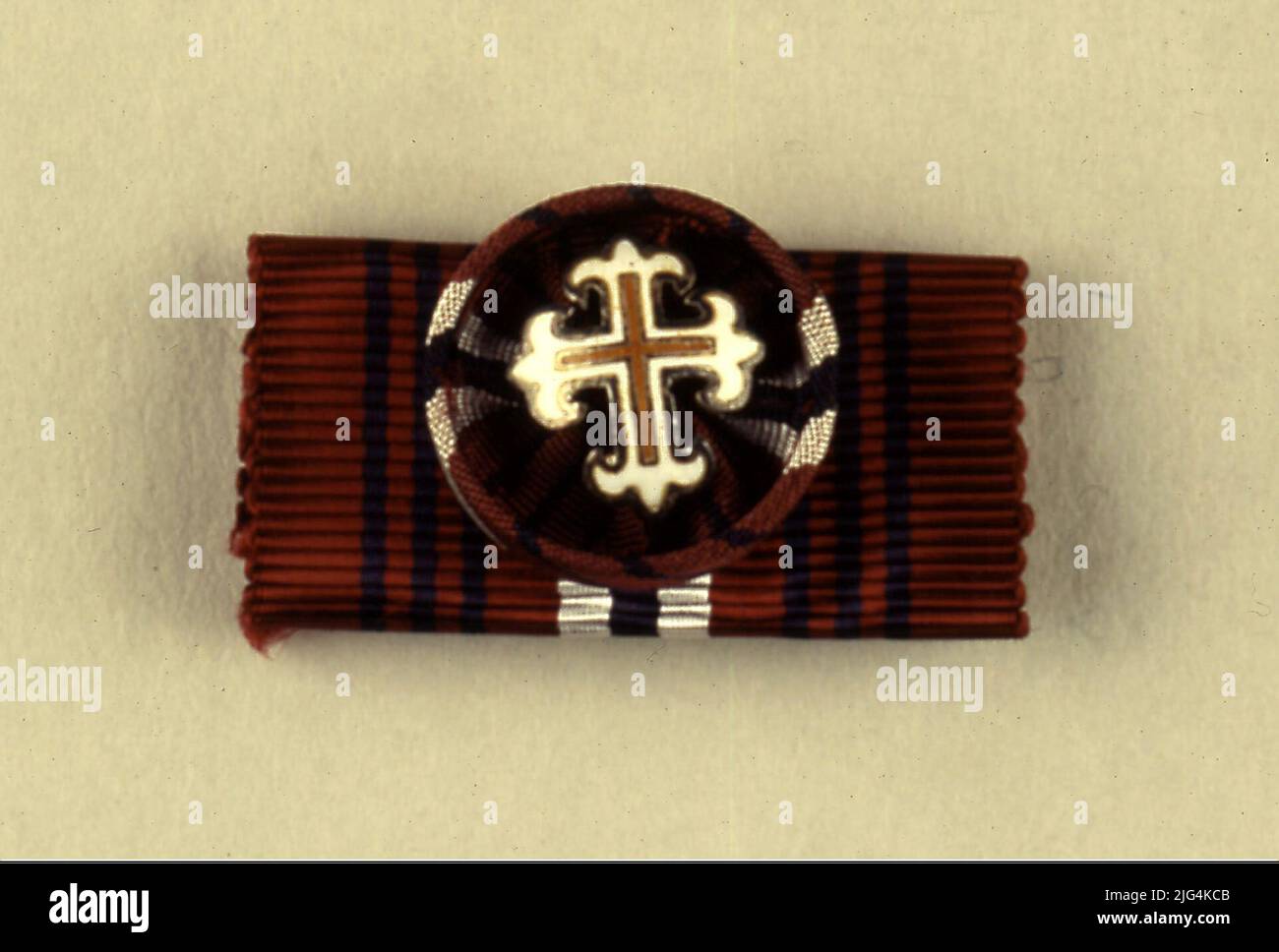 Diario de la Cruz del Mérito Military, Cross of 1st Class, Portugal. Military Medal. Diario de la Cruz del Mérito Military, Cross of 1st Class. Badge used in the newspaper uniform foster by a horizontal tape with the colors of the order of Portuguese military merit (crimson red, with three thin stripes in a white, white and white transverse strips). Attached to the tape, a button is overlap with the cross of the order (Latin cross with unequal arms whose ends end in the form of lis flowers) .Serie: foreign orders/ order of military merit: Méritomateria medal: overdied metal, moaré de Silk, ena Stock Photo