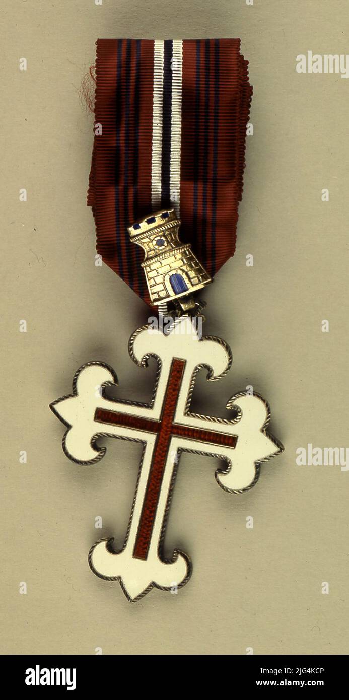 Simple Military Merit Cross, 1st class cross, Portugal. Individual military medal. Military merit medal, first class. Award composed of a Latin cross, with unequal arms, plans and white enamels, whose ends end in the form of lis flowers; It is profiled gold. On the longitudinal and transversal axes, a Latin cross enameled in crimson red and also profiled gold. : Spanish orders / Order of Meritable Merit: Méritomateria Medal: Overdored metal, Silk moaré, enamel Stock Photo