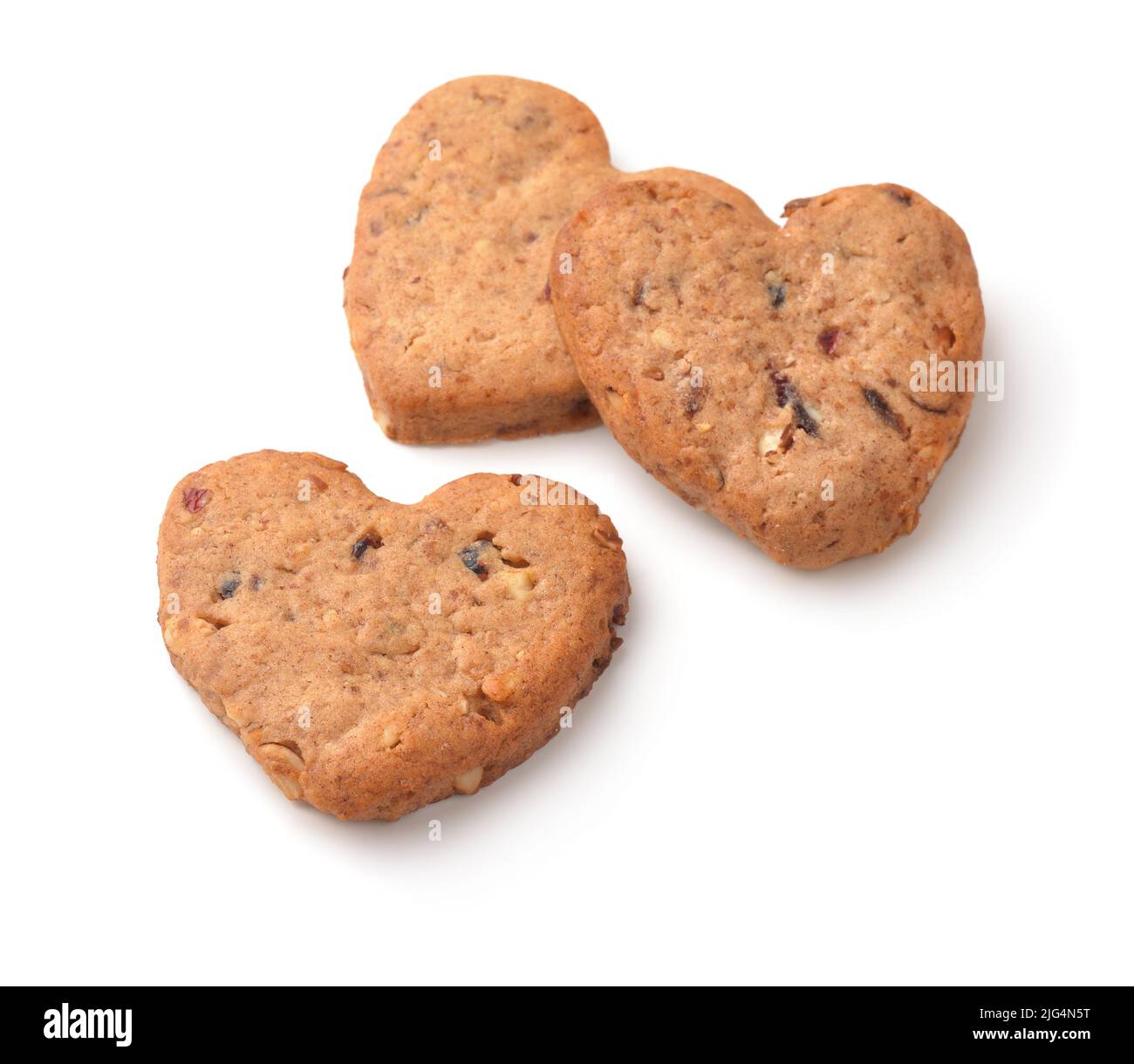 Three homemade oatmeal heart cookies with nuts and raisins isolated on white Stock Photo