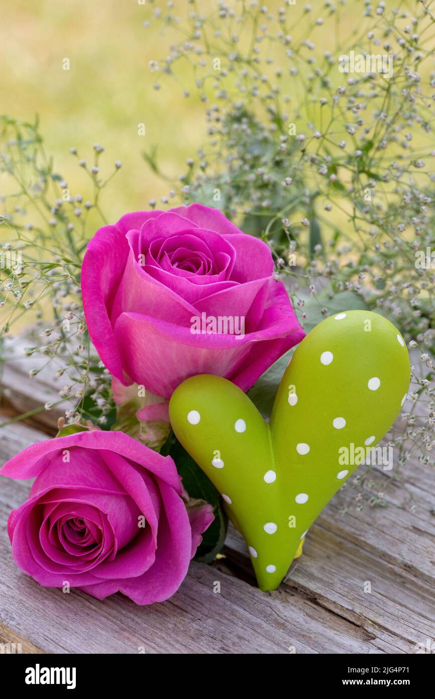 Outdoor holiday decoration with pink roses and green heart Stock Photo