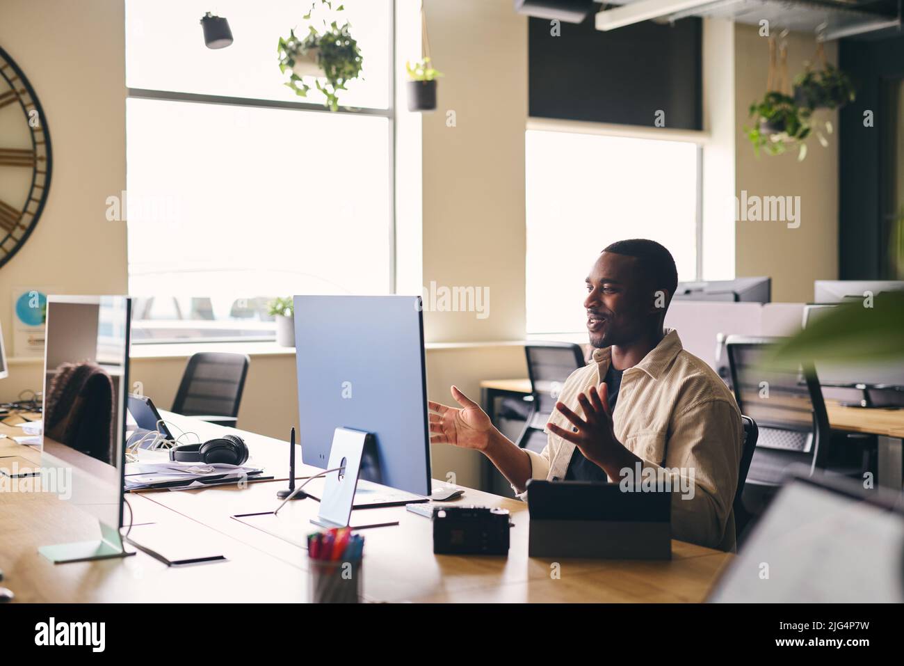 Young Black Man Having Video Conference Call Remotely With Team In Modern Office Sitting At Desk On Computer Stock Photo