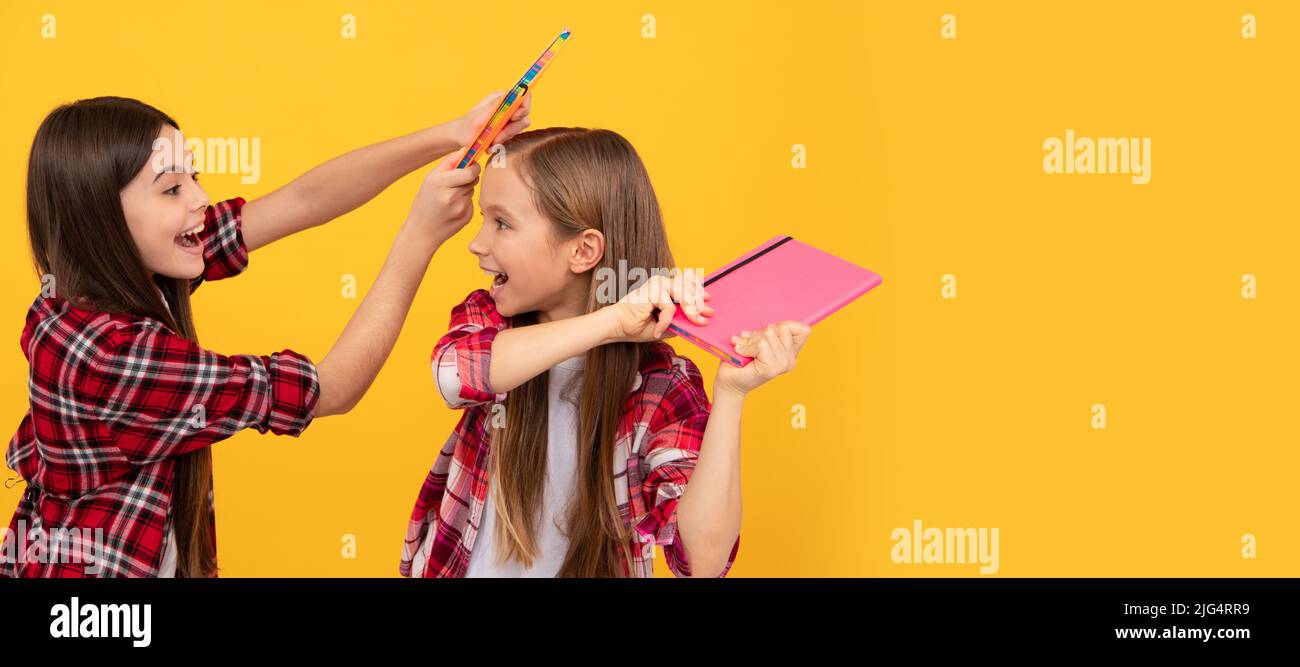 School girls friends. happy teen girls in checkered shirt playing with notebooks, positive emotions. Portrait of schoolgirl student, studio banner Stock Photo