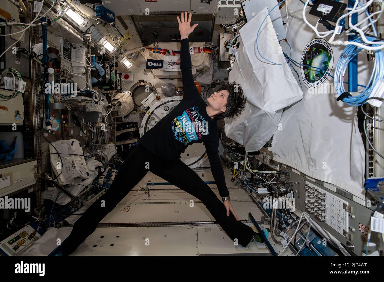 International Space Station Expedition 67 Flight Engineer Samantha Cristoforetti of the ESA, exercises and practices yoga maneuvers while attached to hand and foot rails inside the Kibo laboratory module aboard the orbiting spacelab, June 21, 2022 in Earth Orbit. Stock Photo