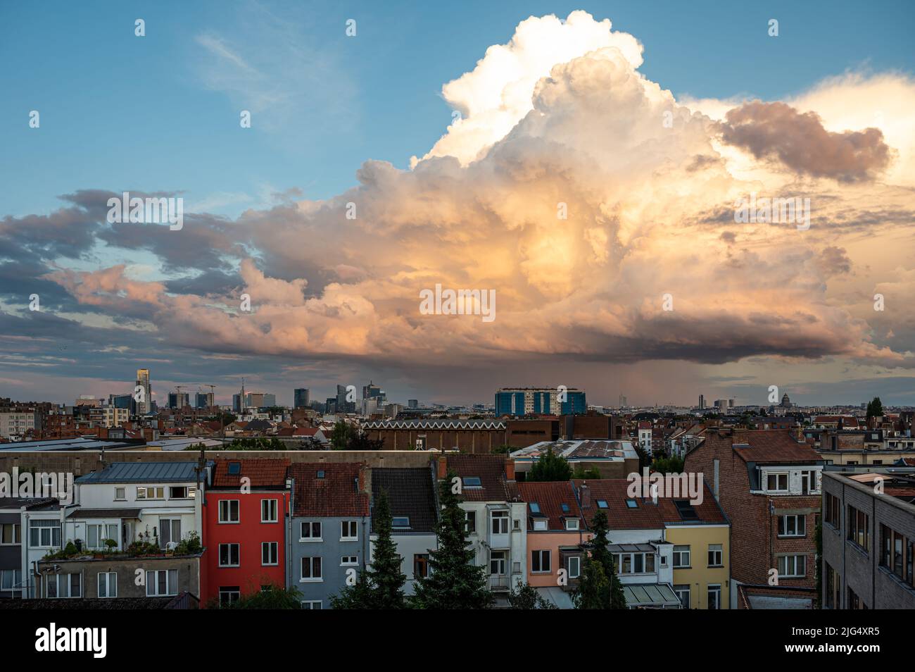 Jette, Brussels Capital Region, Belgium - 06 26 2022 - Panoramic cityscape view during the golden hour with a large cumulus cloud Stock Photo