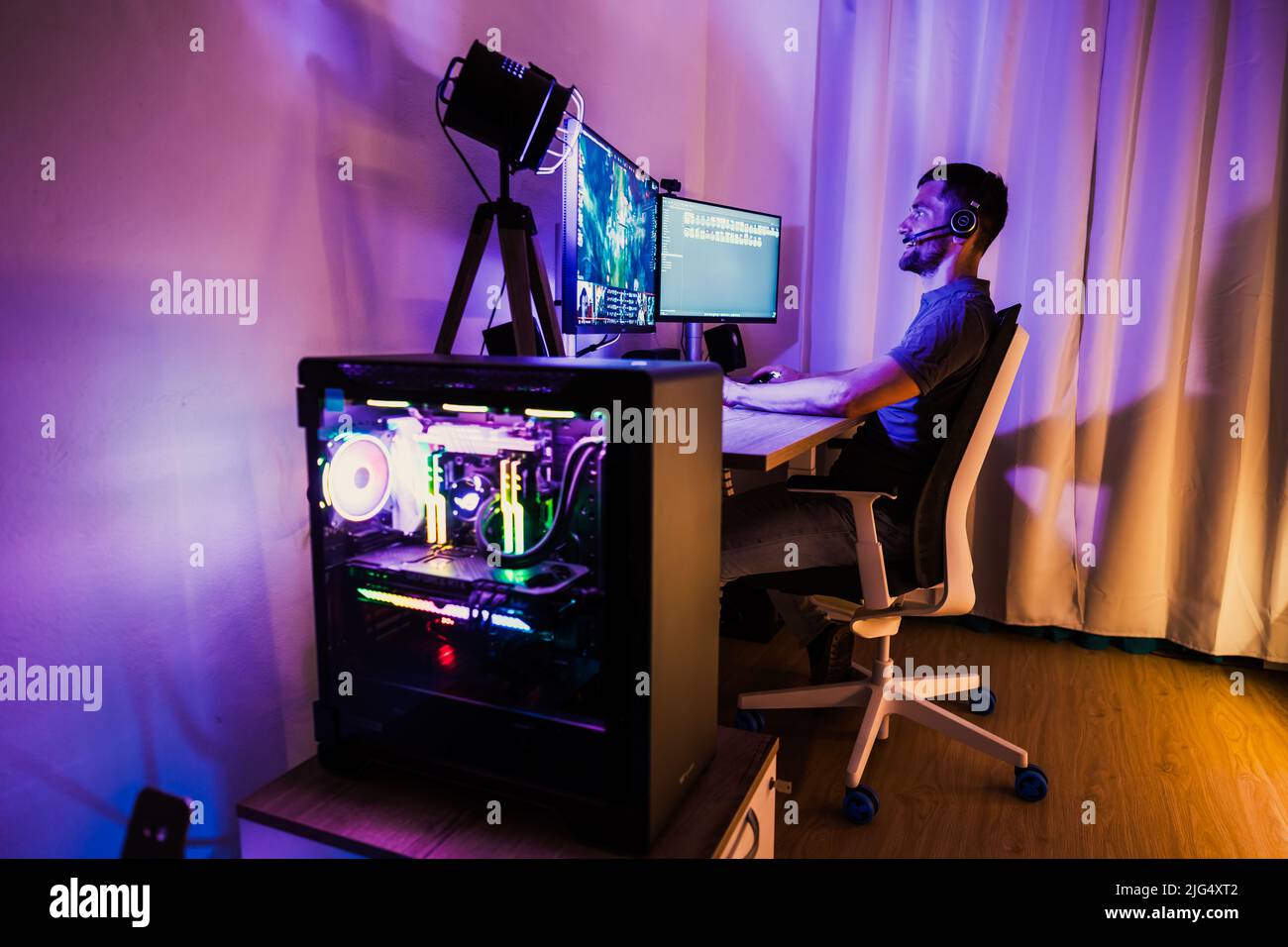 A man is gaming with a high end gaming pc Stock Photo