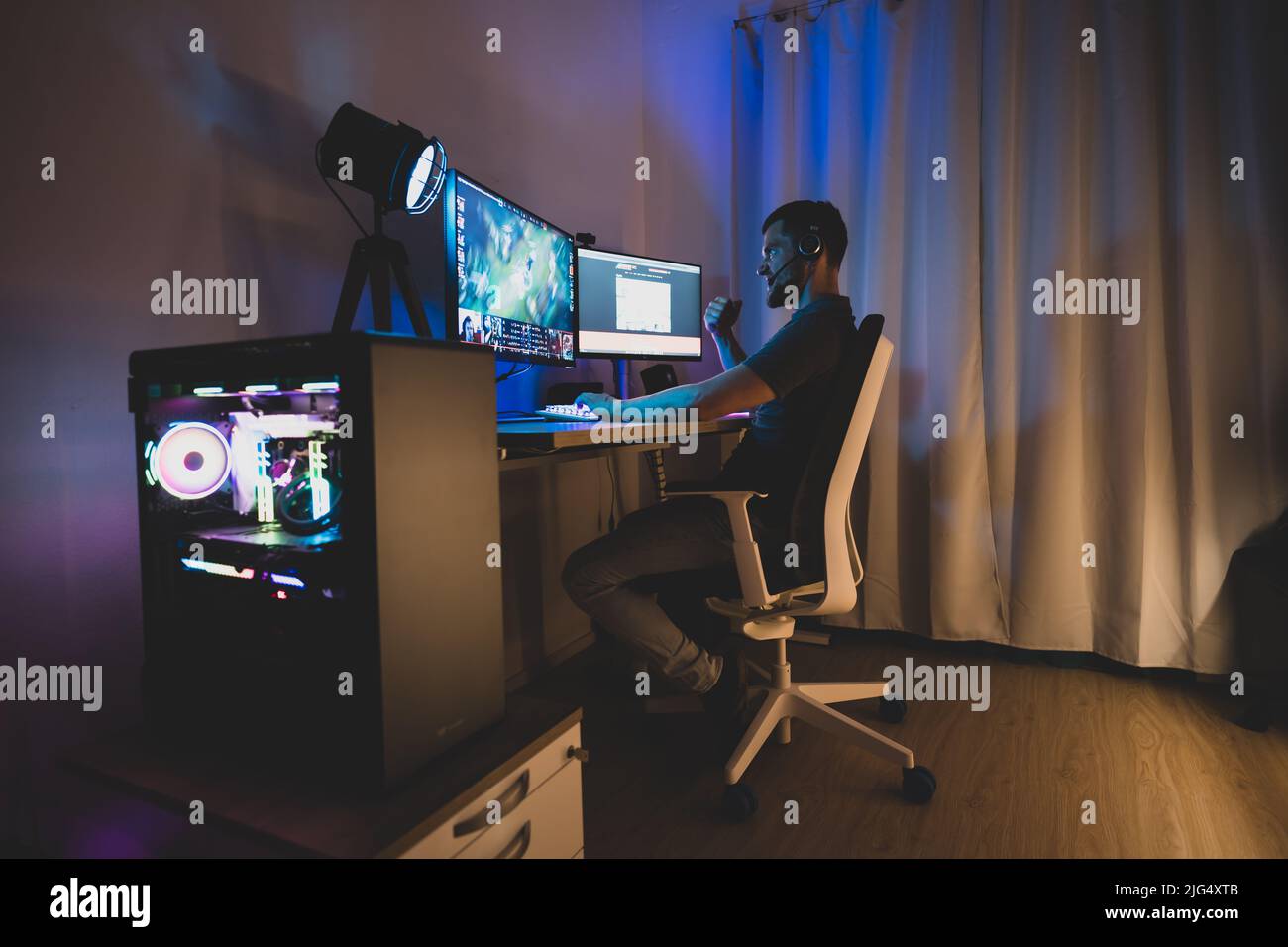 A man is gaming with a high end gaming pc Stock Photo