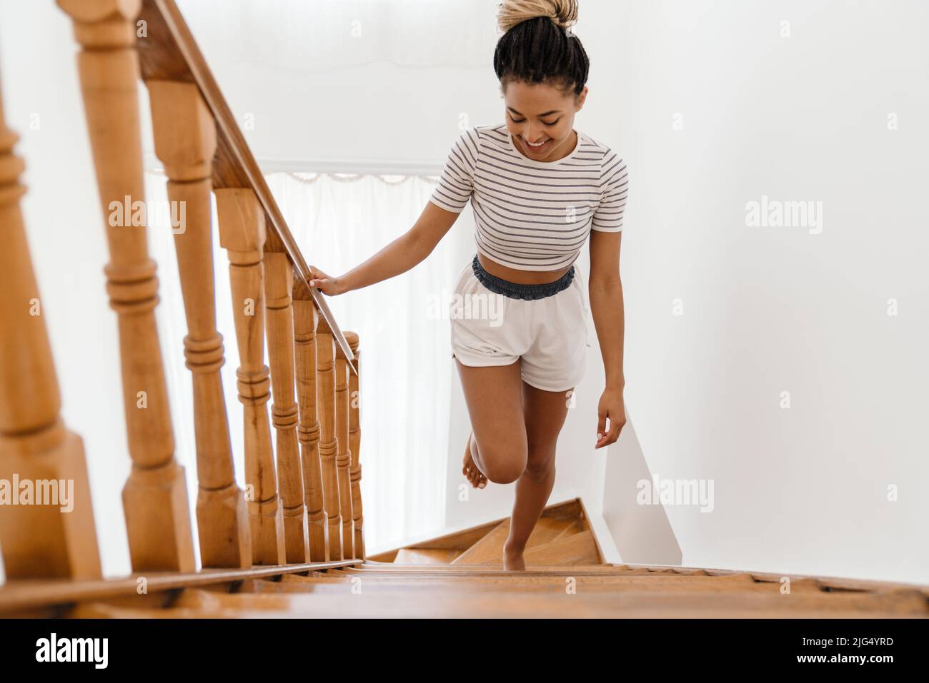Woman going up stairs at home hi-res stock photography and images - Alamy