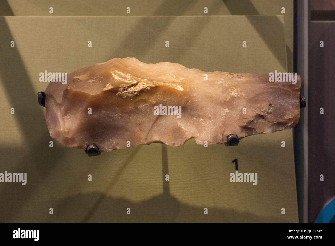 A stone pick originally from Carnac, France (c.10,000-4,500 BC) but discovered in England on display in the UK. Stock Photo