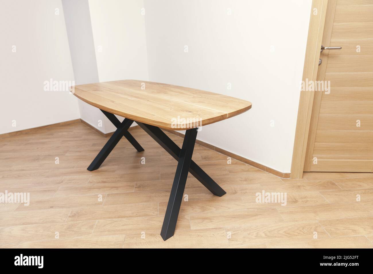 wooden table with black legs in empty room Stock Photo