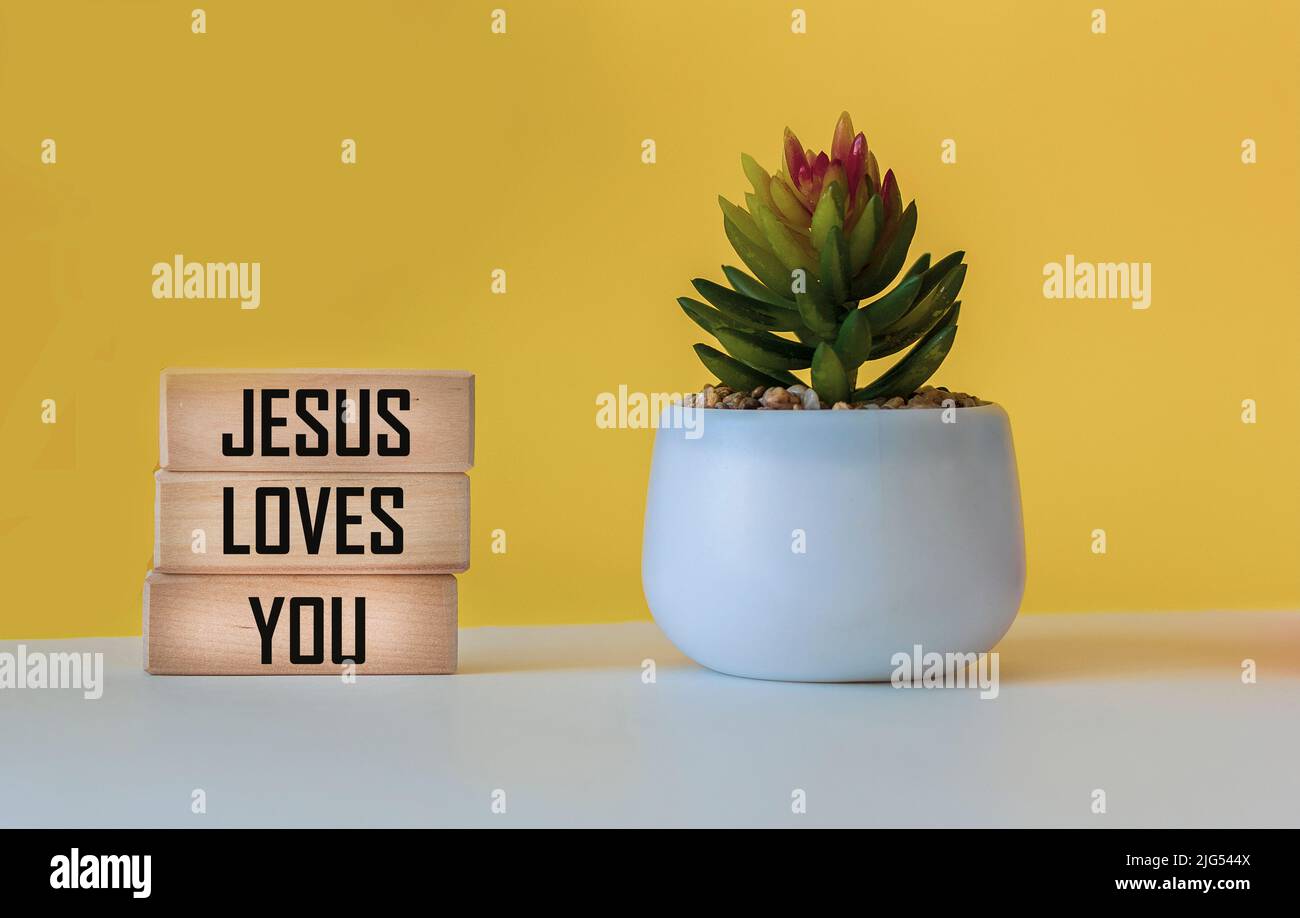 Jesus loves you written on wooden blocks and white and yellow ...