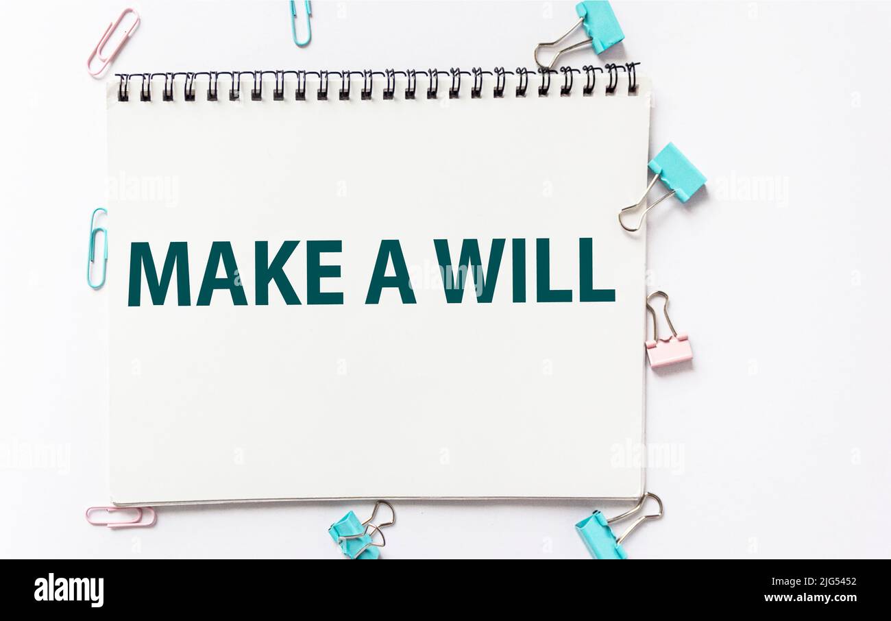 MAKE CONQUEST word on notepad with office paper clips on white