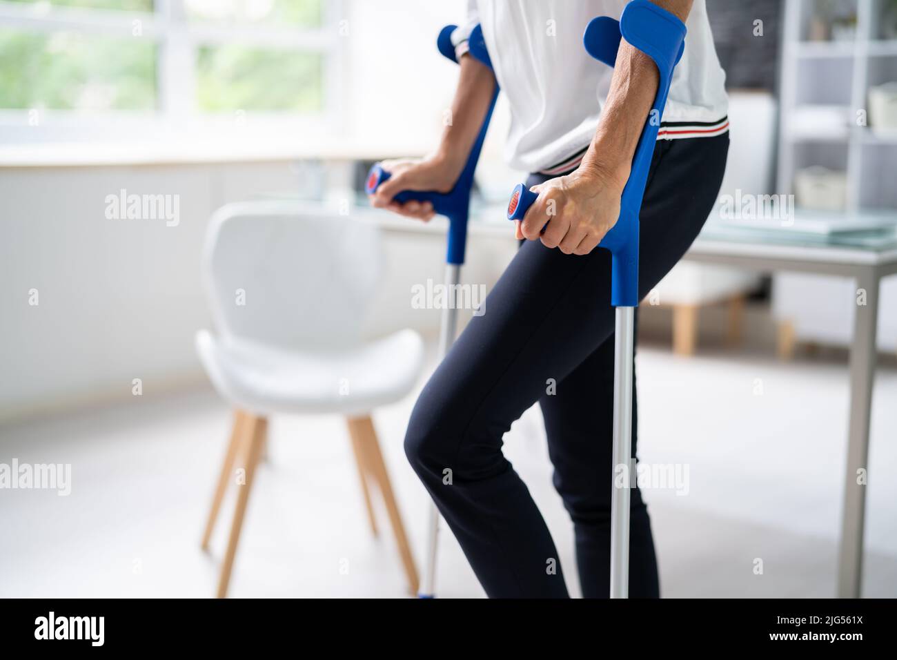 Disabled Woman Using Crutches To Walk At Home Stock Photo Alamy
