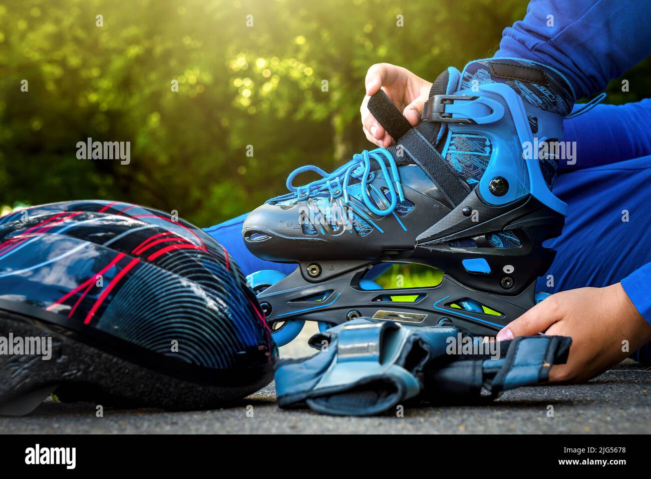 The boy puts on blue roller skates. Sport. Rollers Stock Photo Alamy