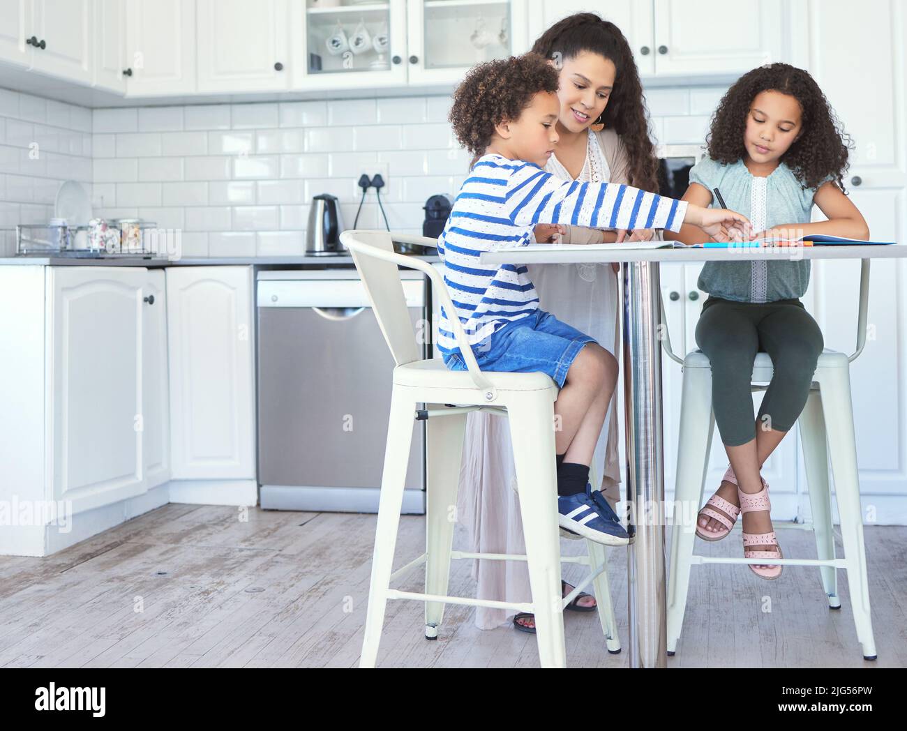Moms invested in our education. Shot of a mother helping her kids with ...