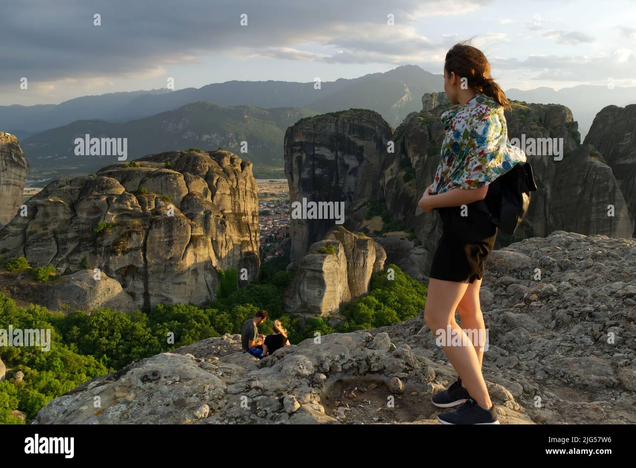 Young girl tourist on the top of the mountain at sunset. Greece, Meteora Stock Photo