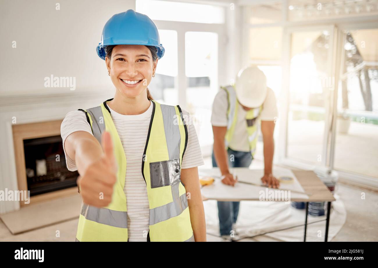 Your living space is going to look great. Shot of an attractive young construction worker standing inside and making a thumbs up gesture. Stock Photo