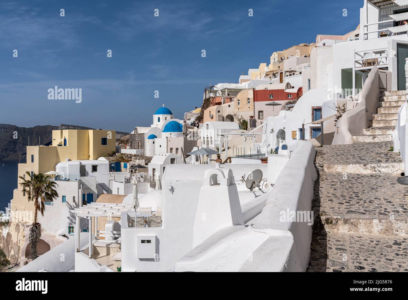 View of Oia village in Santorini with traditional white houses and blue domes churches, Greece Stock Photo