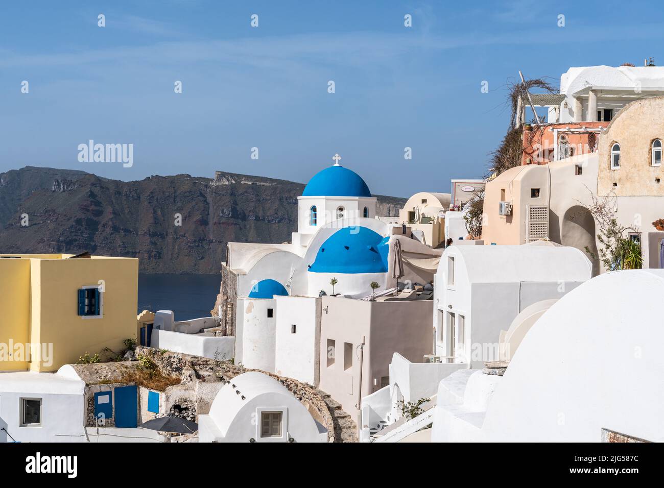 View of Oia village in Santorini with traditional white houses and blue domes churches, Greece Stock Photo